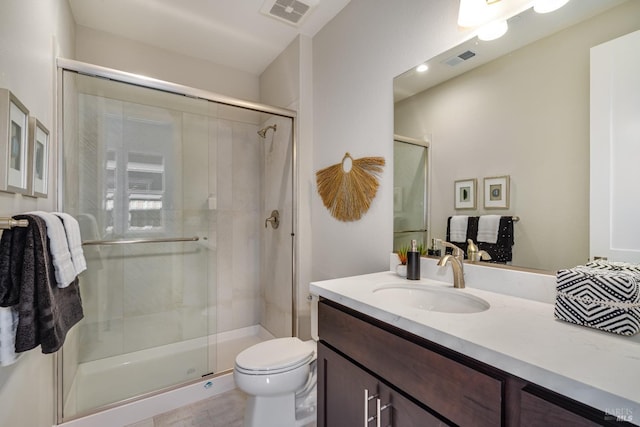 bathroom featuring toilet, vanity, and walk in shower