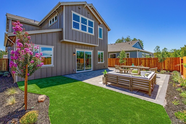 back of property featuring an outdoor living space, a yard, and a patio