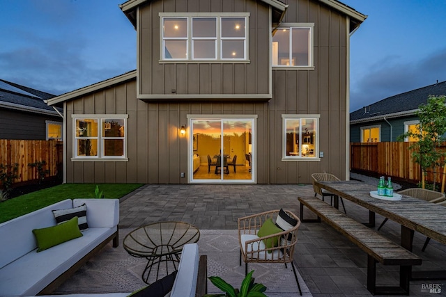 back house at dusk featuring an outdoor hangout area and a patio