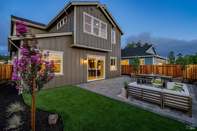 rear view of house featuring a yard, an outdoor living space, and a patio