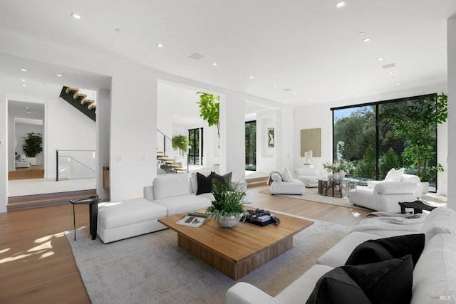 living room with a wall of windows and light hardwood / wood-style flooring