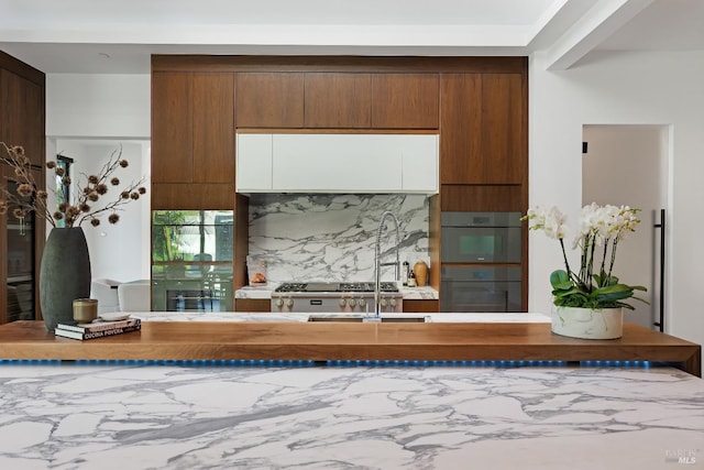 kitchen with tasteful backsplash and black double oven