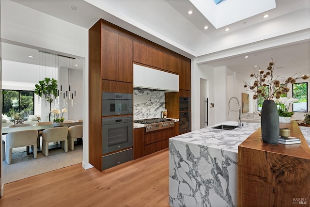 kitchen featuring appliances with stainless steel finishes, tasteful backsplash, a sink, and modern cabinets
