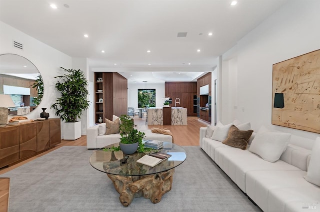 living room featuring light wood-style floors, recessed lighting, and visible vents
