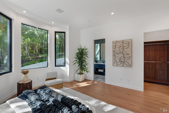 bedroom featuring recessed lighting, baseboards, a walk in closet, and light wood finished floors