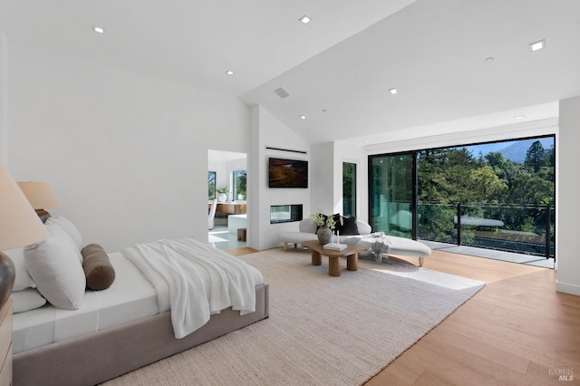 bedroom with access to outside, high vaulted ceiling, and light hardwood / wood-style floors