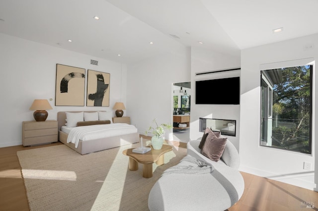 bedroom with lofted ceiling and light wood-type flooring