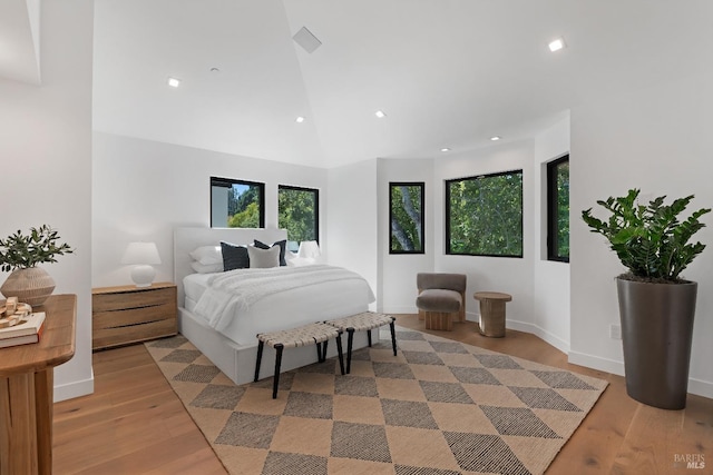 bedroom with light hardwood / wood-style floors and vaulted ceiling