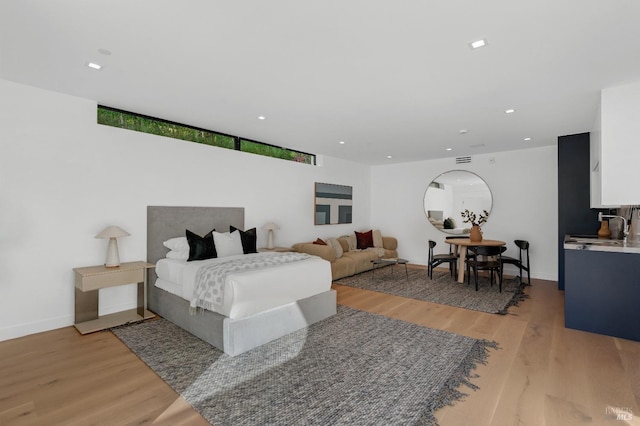 bedroom with sink and light hardwood / wood-style floors