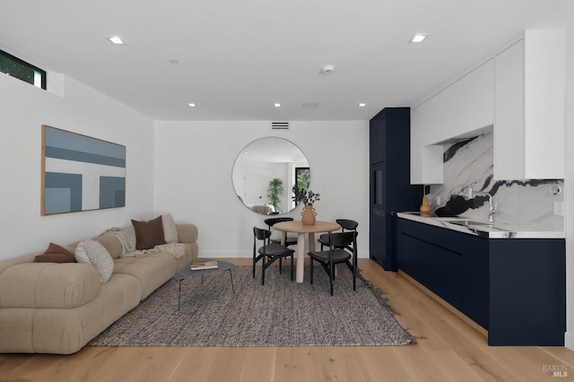 living room featuring sink and light hardwood / wood-style floors