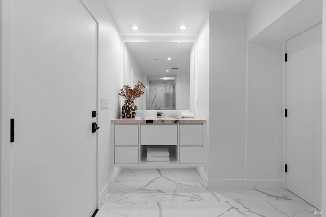 hall featuring baseboards, recessed lighting, and marble finish floor