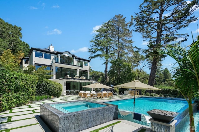 view of pool featuring a patio area and an in ground hot tub