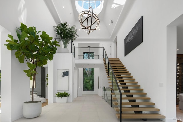 entrance foyer featuring a notable chandelier and a towering ceiling