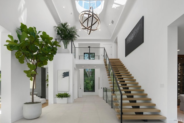 interior space featuring a high ceiling, stairs, visible vents, and a chandelier