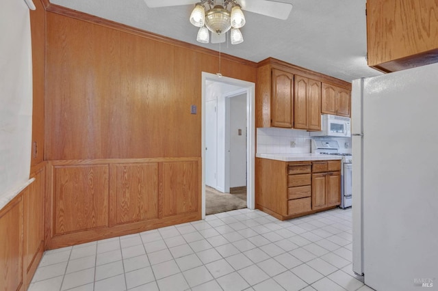 kitchen featuring ceiling fan, light tile patterned floors, backsplash, and white appliances