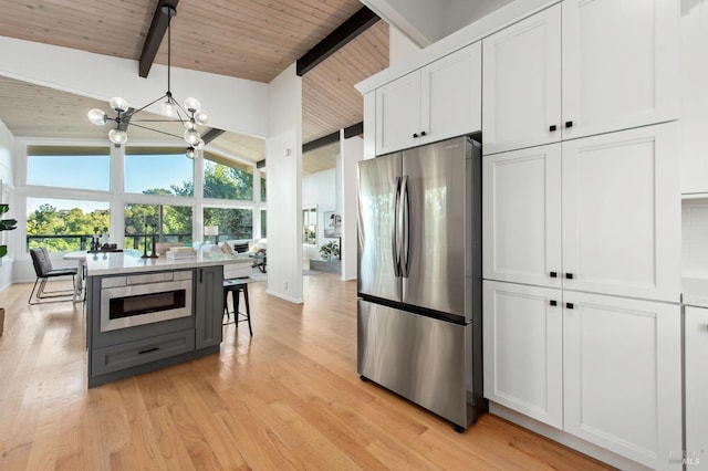 kitchen featuring white cabinetry, wood ceiling, stainless steel appliances, and beamed ceiling