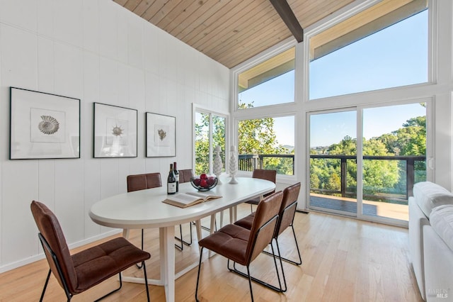 dining space featuring beamed ceiling, high vaulted ceiling, wood ceiling, and light hardwood / wood-style floors