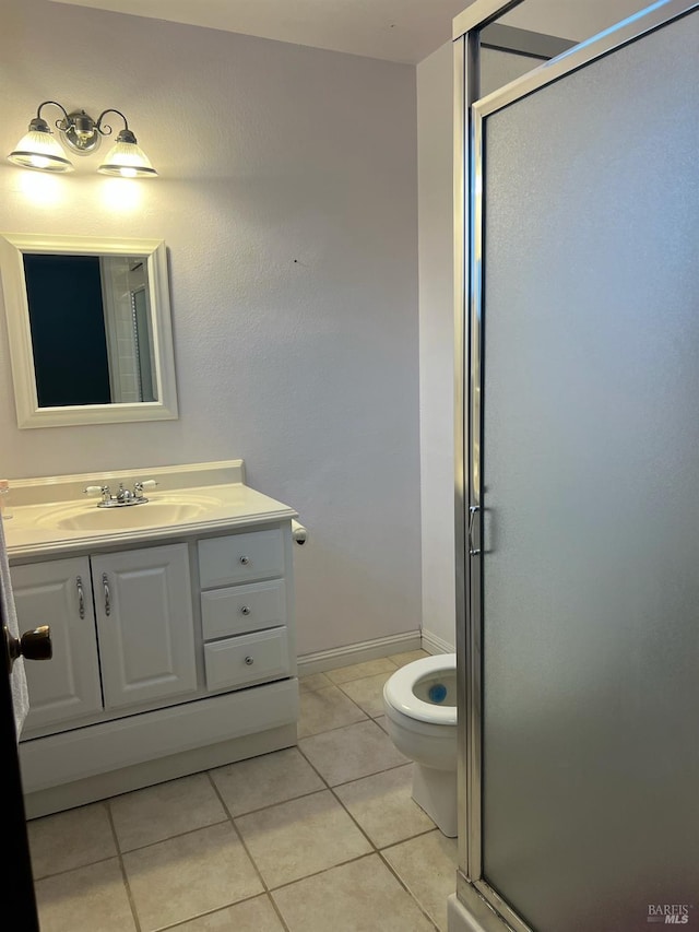 bathroom featuring a shower with door, toilet, vanity, and tile patterned flooring