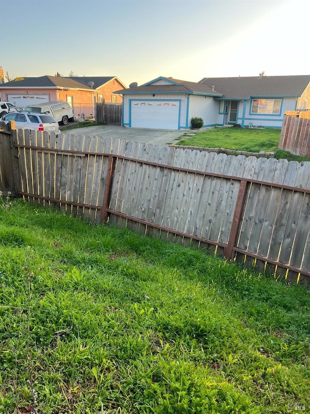 yard at dusk featuring a garage