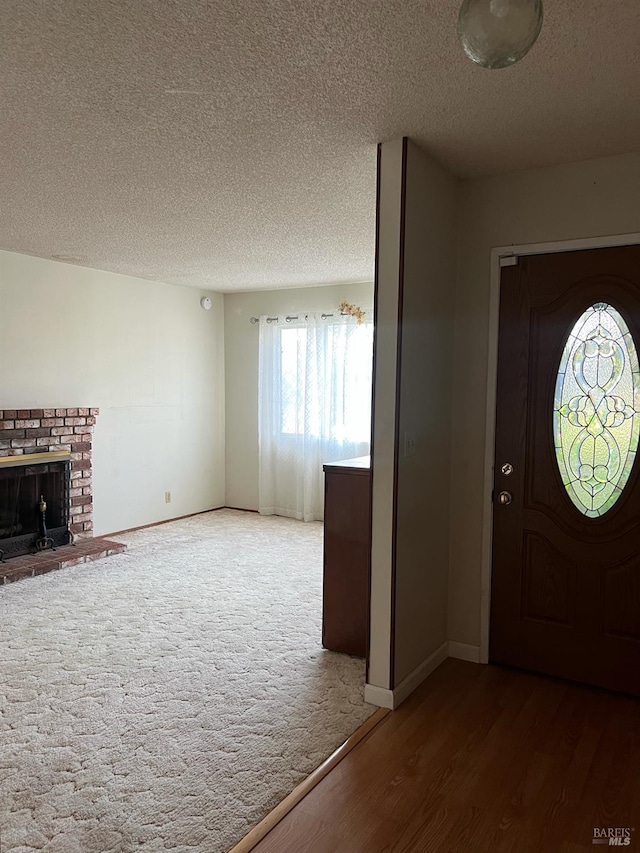 entryway with a fireplace, a textured ceiling, and hardwood / wood-style flooring