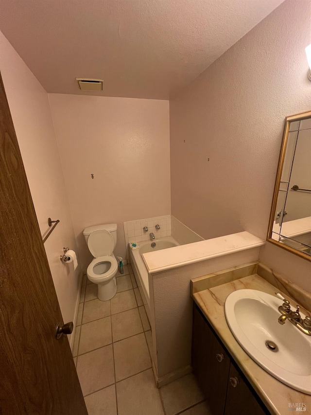 bathroom featuring toilet, tile patterned floors, a tub, a textured ceiling, and vanity