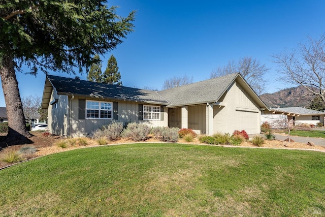 view of front of home featuring a garage, a mountain view, and a front lawn