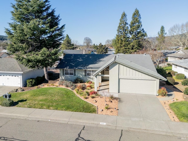 view of front facade with a front yard, concrete driveway, and an attached garage