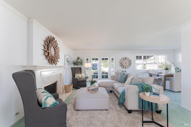 living area featuring carpet floors, baseboards, a fireplace, and ornamental molding