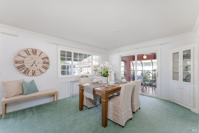 dining room with a sunroom, light colored carpet, and crown molding