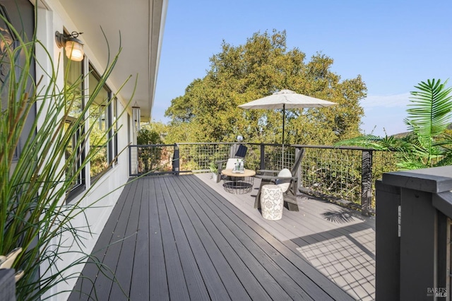 wooden deck featuring an outdoor fire pit