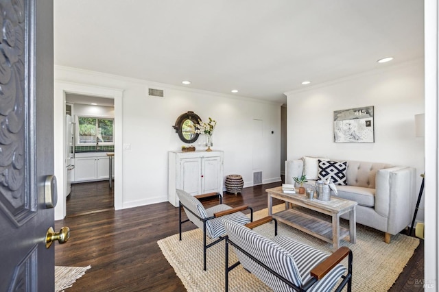 living room featuring dark hardwood / wood-style flooring, ornamental molding, and sink