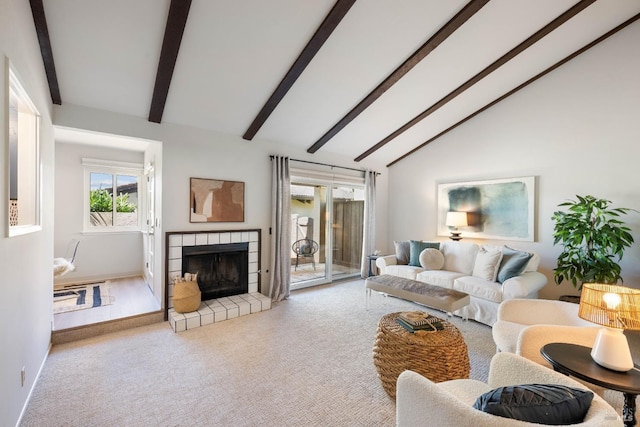 carpeted living room featuring high vaulted ceiling, a tile fireplace, and beamed ceiling