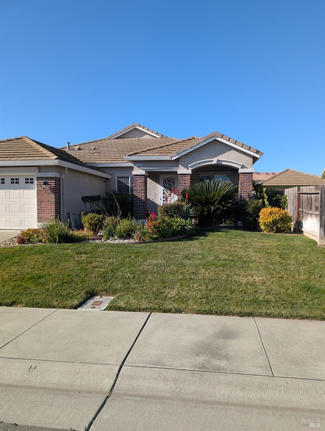 single story home with a garage and a front lawn