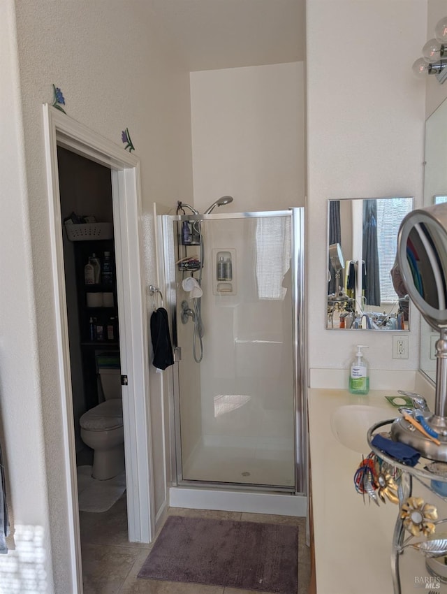 bathroom featuring a shower with shower door, toilet, and vanity