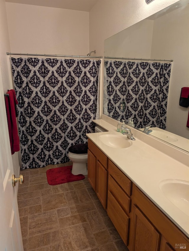 bathroom featuring toilet, a shower with shower curtain, and vanity