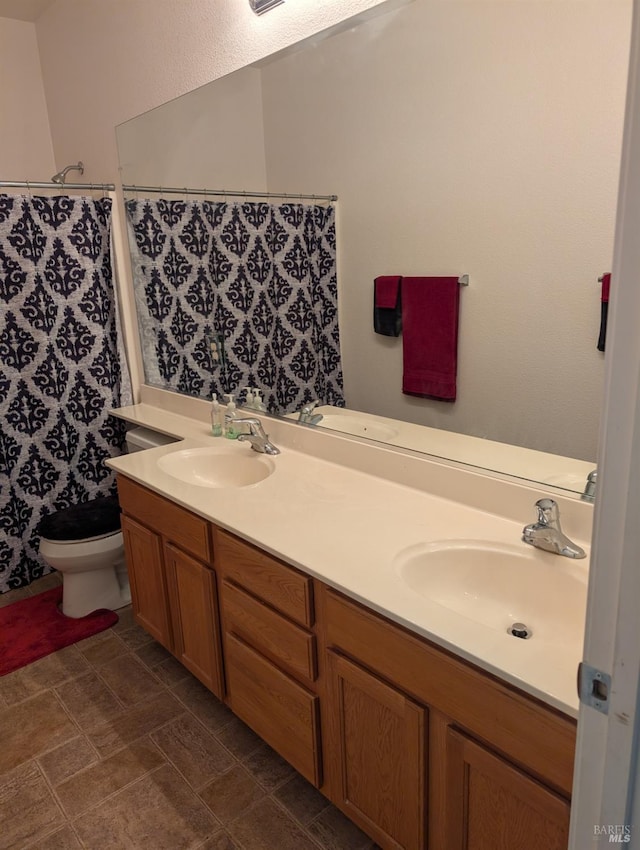 bathroom featuring toilet, walk in shower, and vanity