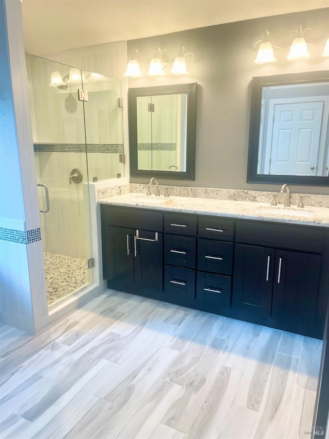 bathroom featuring hardwood / wood-style flooring, vanity, and a shower with shower door