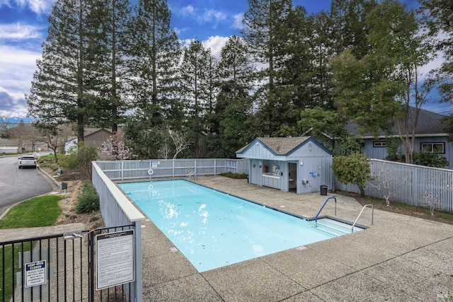 pool featuring a patio, an outdoor structure, and fence