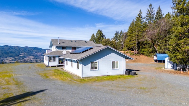 view of front of property featuring a mountain view and solar panels