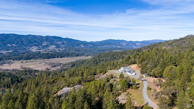 birds eye view of property with a wooded view and a mountain view