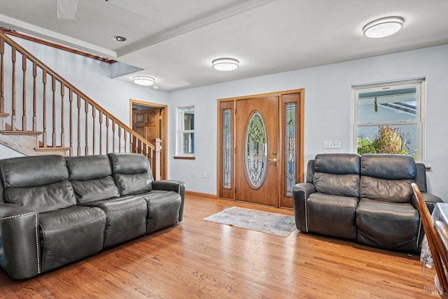 living room with crown molding and light hardwood / wood-style floors