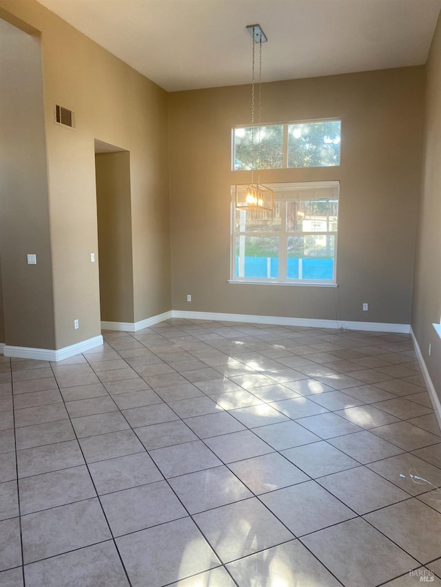 unfurnished dining area featuring light tile patterned flooring and a notable chandelier