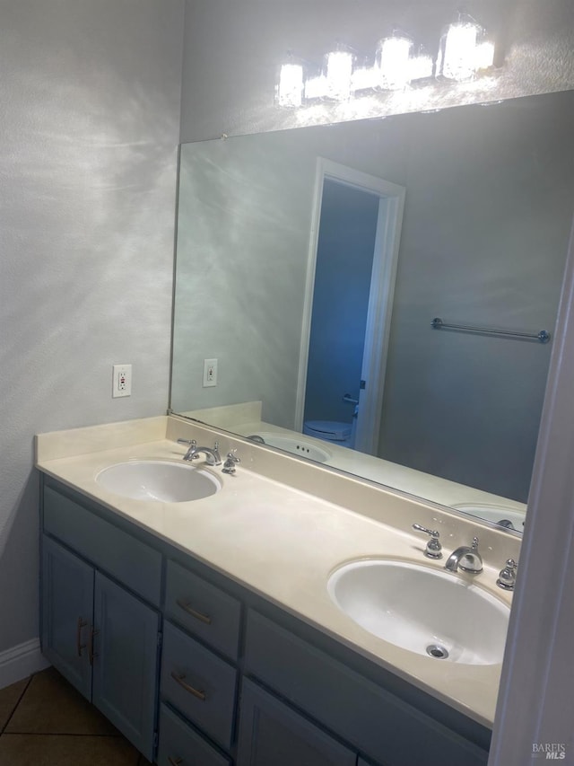 bathroom featuring toilet, tile patterned flooring, and vanity