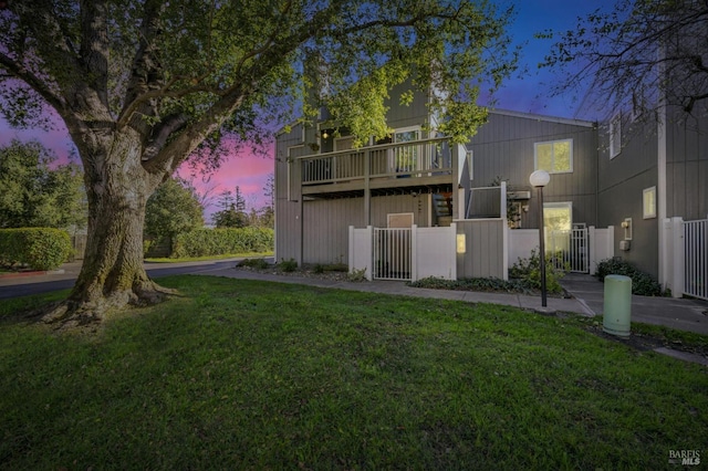 back house at dusk featuring a yard