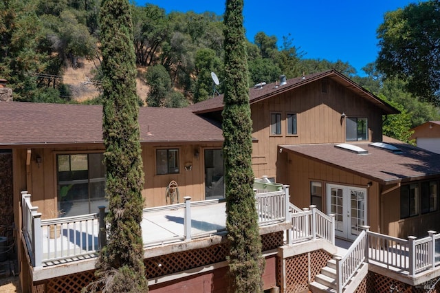 back of property featuring a wooden deck and french doors