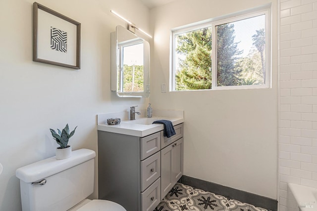 bathroom with toilet, vanity, and tile patterned flooring