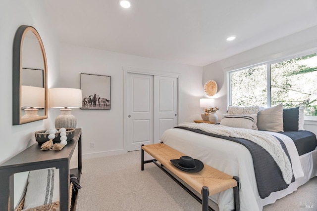 bedroom featuring light colored carpet and a closet