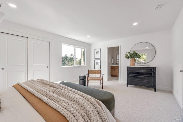 carpeted bedroom with a closet and ensuite bathroom