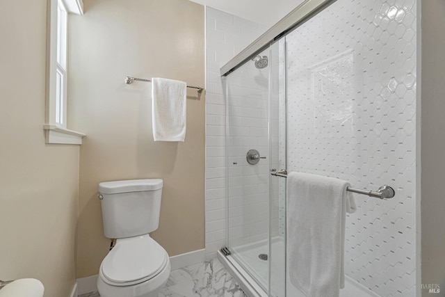 bathroom featuring toilet and a shower with door