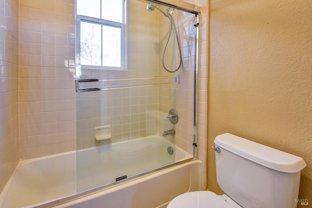 bathroom with shower / bath combination with glass door and toilet